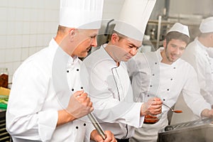 Two male cook work in professional kitchen