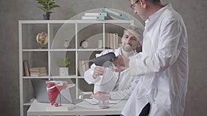 Two male doctors checking x-ray in the office of modern clinic. Men reach consensus and shake hands. Concept of medicine