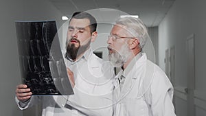 Two male doctors discussing MRI scan of their patient