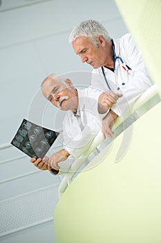 Two male doctors examining x-ray image