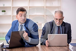 Two male employees working in the office