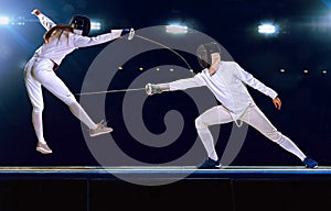 Two fencing athletes fight on professional sports arena photo