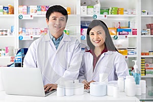 Two Male and female pharmacists smiling happy