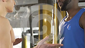 Two male friends having argument in gym, difference in opinions, disagreement