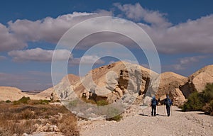 Two male friends on a hiking trail in a remote desert region.