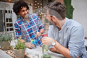 Two male friends socializing in cafe outside