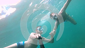 Two male friends take a smiling selfie underwater. Swimming underwater with a friend. underwater selfie