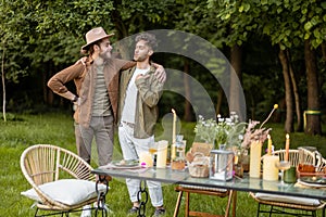 Two male friends talking during a lunch in nature