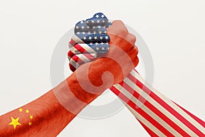 Two male hands competing in arm wrestling colored in China and America flags