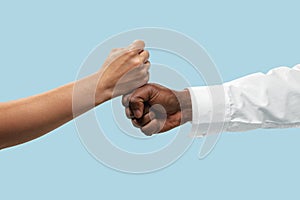 Two male hands competion in arm wrestling isolated on blue studio background