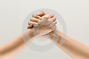 Two male hands competion in arm wrestling isolated on grey studio background