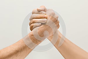 Two male hands competion in arm wrestling isolated on grey studio background