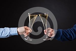 Two male hands holding champagne glasses