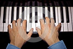 Two male hands on the piano. palms lie on the keys and play the keyboard instrument in the music school. student learns to play.