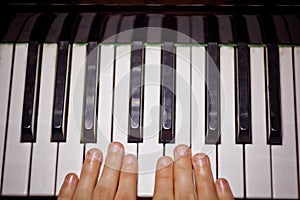 Two male hands on the piano. palms lie on the keys and play the keyboard instrument in the music school. student learns to play.
