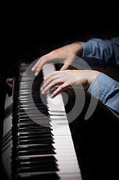 Two male hands on the piano. palms lie on the keys and play the keyboard instrument in the music school. student learns to play.