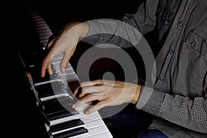 Two male hands on the piano. palms lie on the keys and play the keyboard instrument in the music school. student learns to play.