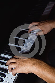 Two male hands on the piano. palms lie on the keys and play the keyboard instrument in the music school. student learns to play.