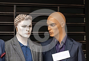Two male mannequins dressed in suits advertise clothes in a street market in Belgrade.