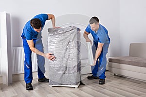 Two Male Movers Packing Furniture photo