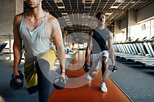 Two male persons doing exercise with dumbbells