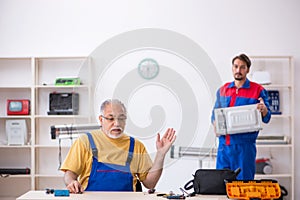 Two male repairmen working at workshop