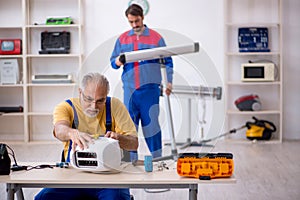 Two male repairmen working at workshop
