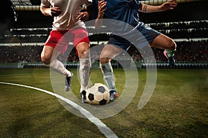 Two male soccer, football players dribbling ball at the stadium during sport match at crowed stadium. Sport concept