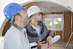 Two male tradesmen with paint colour charts in development property photo