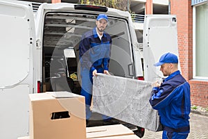 Two Male Worker Unloading Furniture From Truck