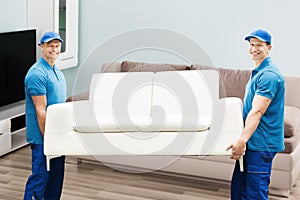 Two Male Workers Carrying Sofa