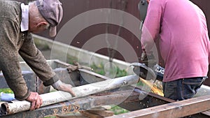 Two male workers cutting metal sheets with electric grider in the workshop