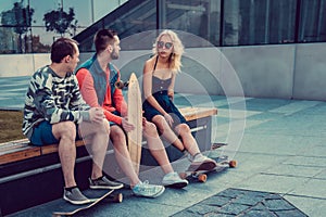Two males and one female with longboards.