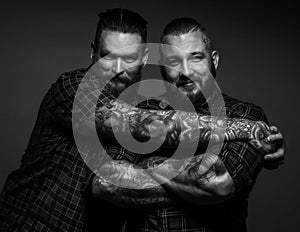 Two males with tattos on arms