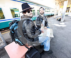 Two males are waiting for the train.