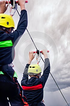 Two males on zip line on cloudy day