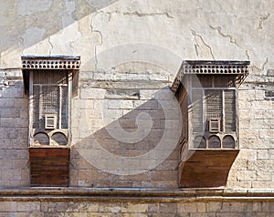 Mamluk era style oriel windows with interleaved wooden grid - Mashrabiya, on shabby wall, Cairo photo