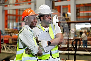 Two man African American engineer workers standing work success in manufacturing factory workplace. happy man engineering at