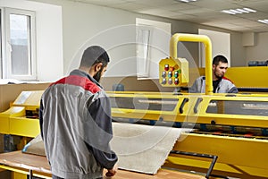 Two man operating professional cleaning equipment in laundry service cleaning carpet