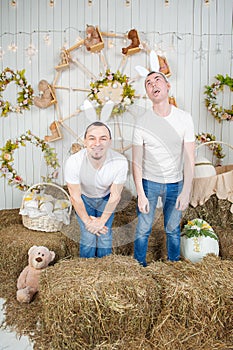 Two man with rabbit ears having fun standing in the haystack