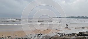 Two man walk when Small ocean waves breaking on beach