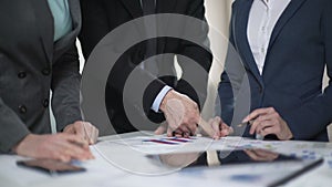 Two manager ladies and male boss comparing sales charts and investment plans