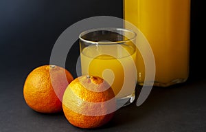 Two mandarin oranges, tangerines with glass of juice isolated on