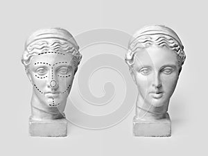 Two marble heads of young women, ancient Greek goddess bust marked with lines for plastic surgery and sculpture after