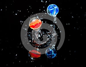 Two marbles bouncing on wet surface
