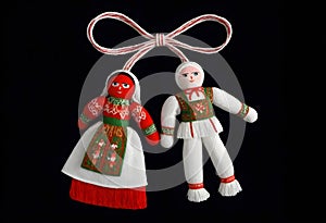 two martenitsa dolls in traditional russian clothing are hanging from a ribbon