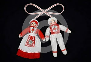 two martenitsa dolls in traditional russian clothing are hanging from a ribbon