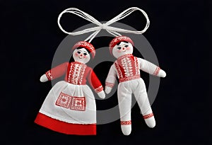 two martenitsa dolls in traditional russian clothing are hanging from a ribbon