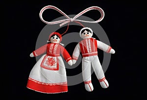 two martenitsa dolls in traditional russian clothing are hanging from a ribbon