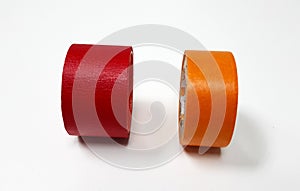 Two masking tapes roll red and orange isolated on white background.